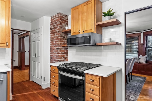 kitchen featuring appliances with stainless steel finishes, dark hardwood / wood-style floors, and decorative backsplash