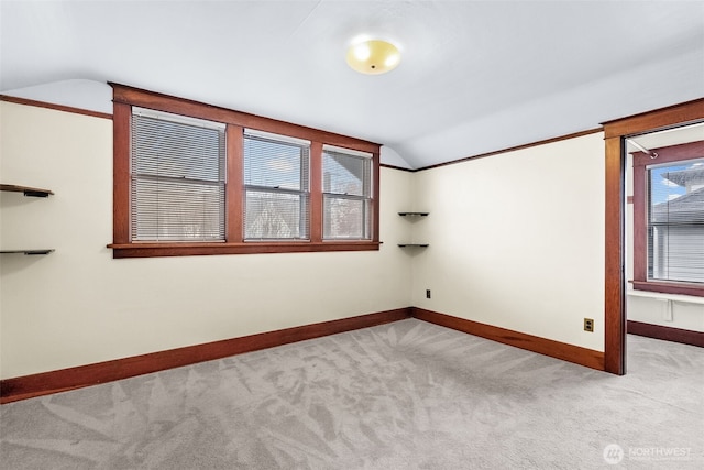 carpeted empty room featuring lofted ceiling