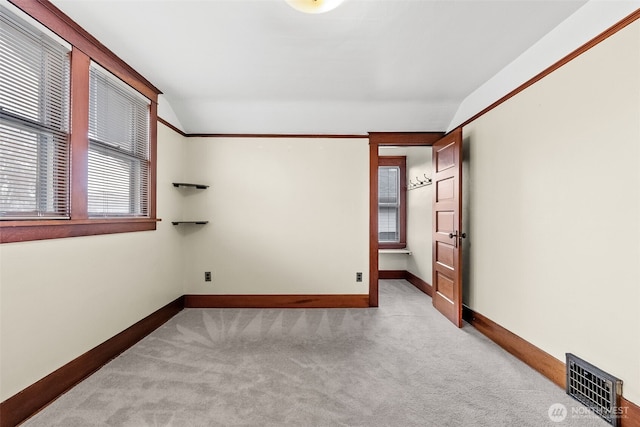 empty room featuring light carpet and lofted ceiling