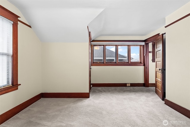 interior space with light carpet, lofted ceiling, and a healthy amount of sunlight