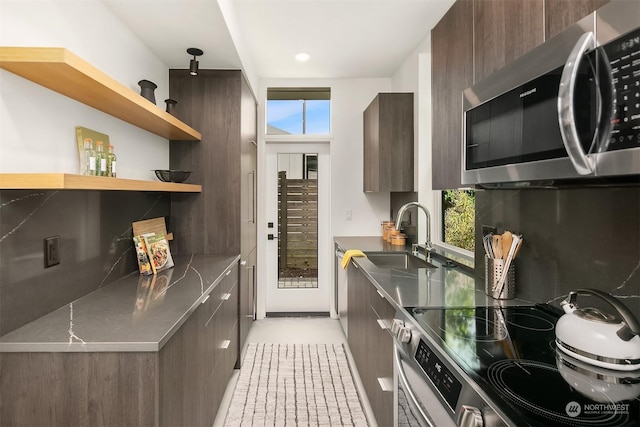 kitchen with sink, decorative backsplash, dark brown cabinets, and stainless steel appliances