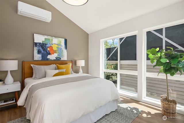 bedroom featuring hardwood / wood-style flooring, a wall mounted AC, and vaulted ceiling