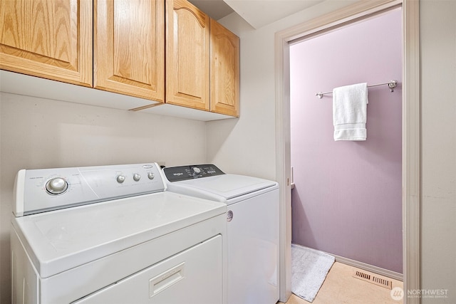 laundry room with cabinets and washer and clothes dryer