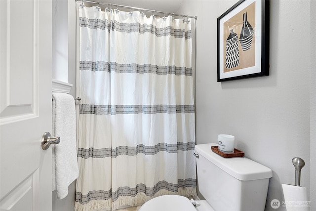 bathroom featuring a shower with curtain and toilet