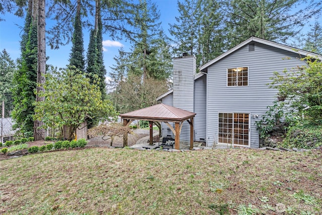 rear view of house with a gazebo and a yard