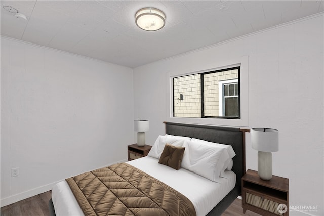 bedroom featuring crown molding and dark hardwood / wood-style flooring