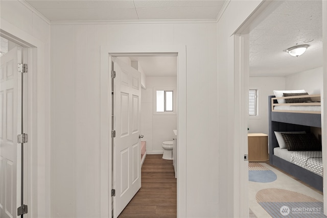 interior space with hardwood / wood-style flooring, a textured ceiling, and toilet