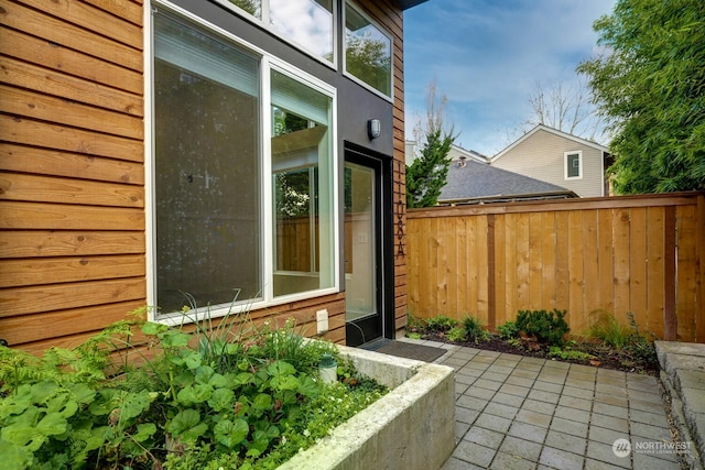 view of property exterior with a patio area and fence