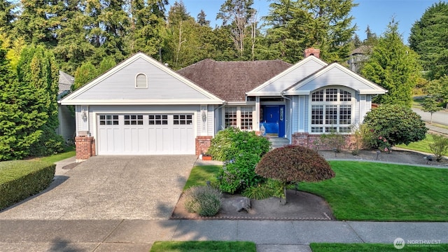 ranch-style house with concrete driveway, a chimney, an attached garage, a front yard, and brick siding