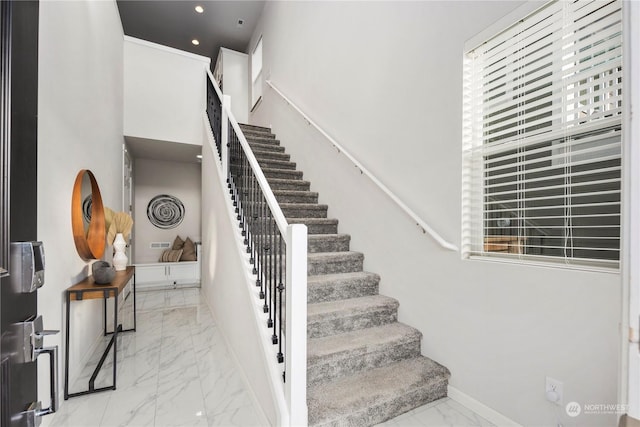 staircase featuring a towering ceiling