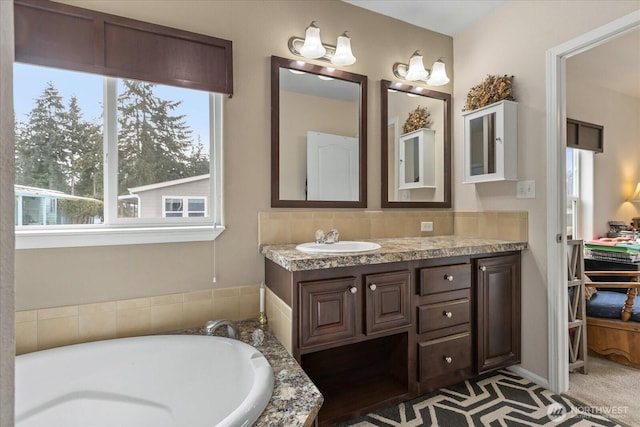 bathroom with a tub and vanity