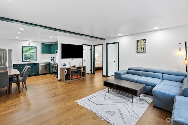 living room with a fireplace, light hardwood / wood-style floors, and a textured ceiling