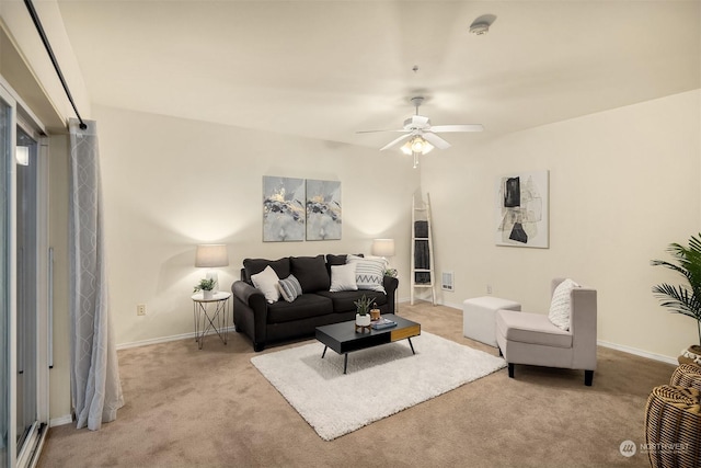 living room featuring baseboards, a ceiling fan, and light colored carpet