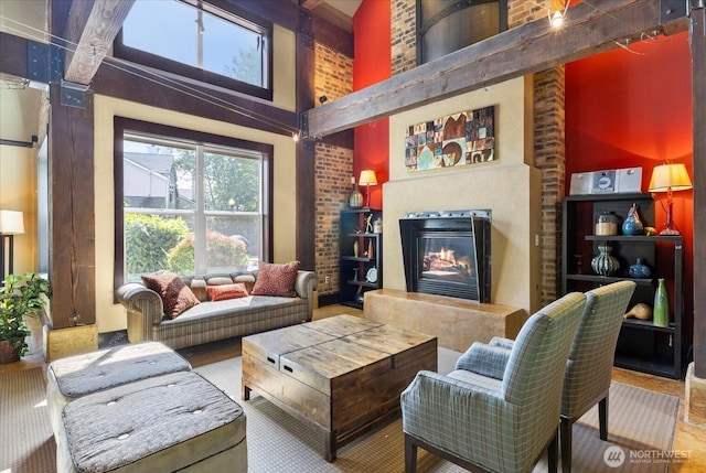 living room with a high ceiling and a glass covered fireplace