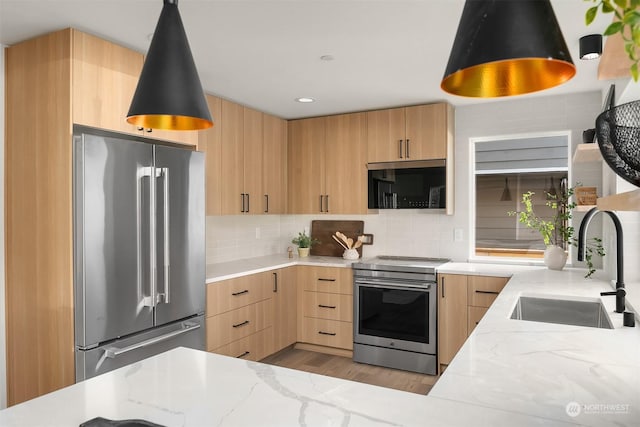 kitchen with appliances with stainless steel finishes, sink, and light brown cabinets