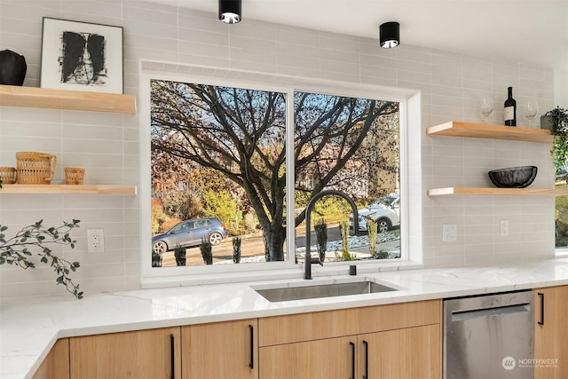 bar featuring light stone counters, sink, and dishwasher