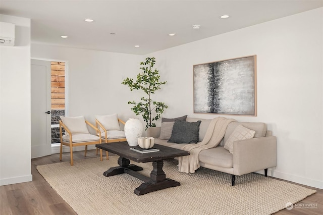 living room featuring hardwood / wood-style floors and an AC wall unit