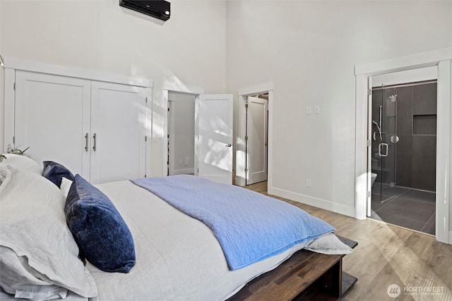 bedroom with a high ceiling and light wood-type flooring