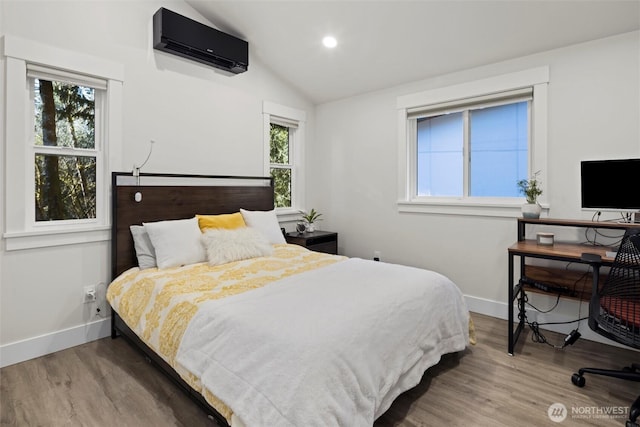 bedroom featuring a wall mounted air conditioner, vaulted ceiling, and wood-type flooring