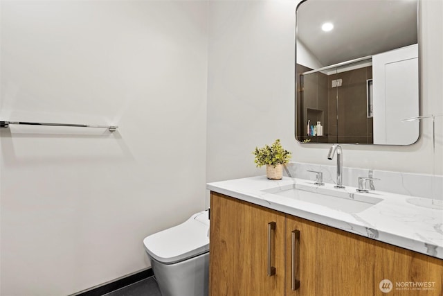 bathroom featuring walk in shower, vanity, and toilet