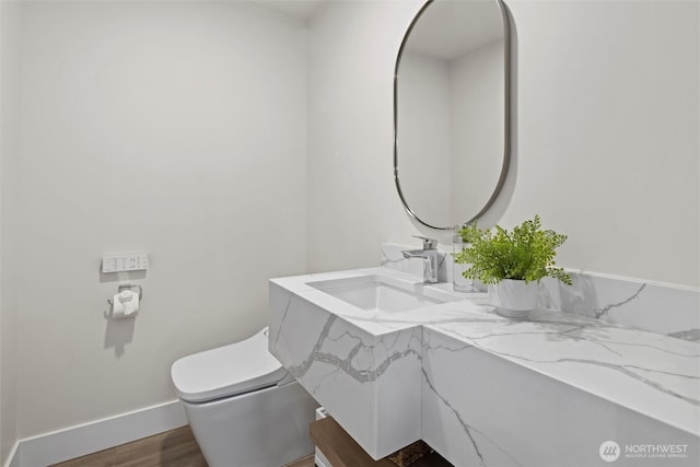 bathroom with hardwood / wood-style flooring, toilet, and sink