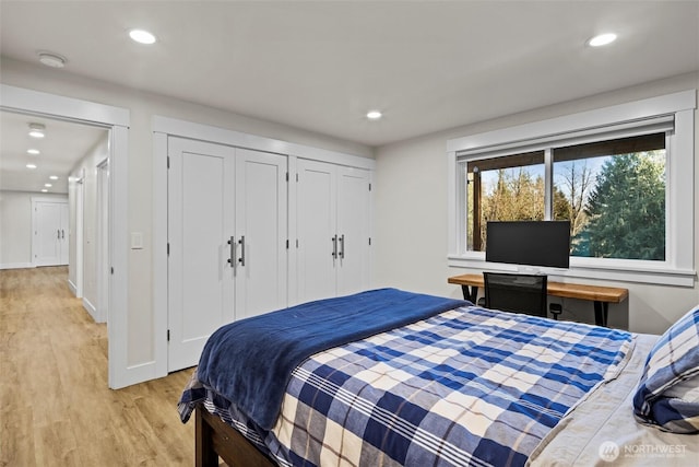 bedroom featuring light hardwood / wood-style floors and two closets