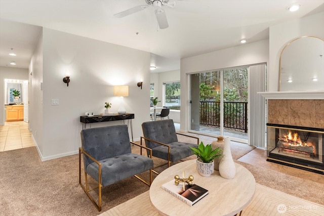 sitting room with recessed lighting, light colored carpet, a tiled fireplace, a ceiling fan, and baseboards