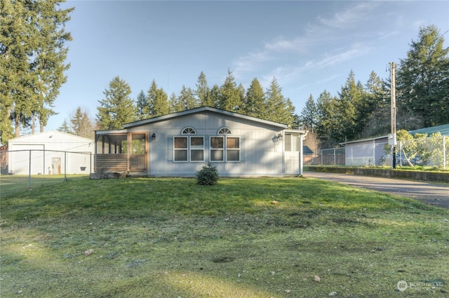 single story home featuring a sunroom and a front yard