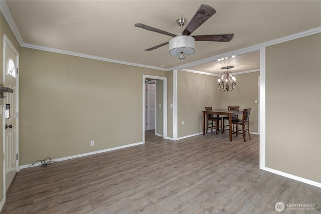 empty room with hardwood / wood-style floors, ceiling fan with notable chandelier, and ornamental molding