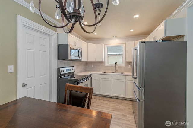 kitchen with white cabinetry, appliances with stainless steel finishes, sink, and backsplash