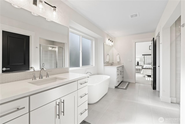 bathroom featuring shower with separate bathtub, vanity, and tile patterned floors