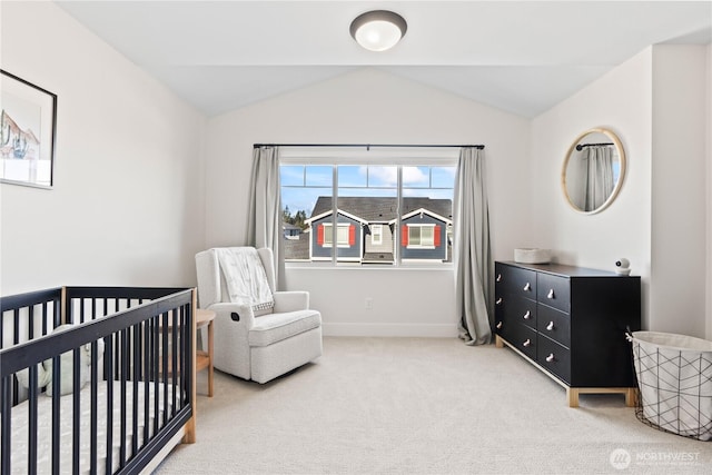 carpeted bedroom featuring a nursery area and vaulted ceiling