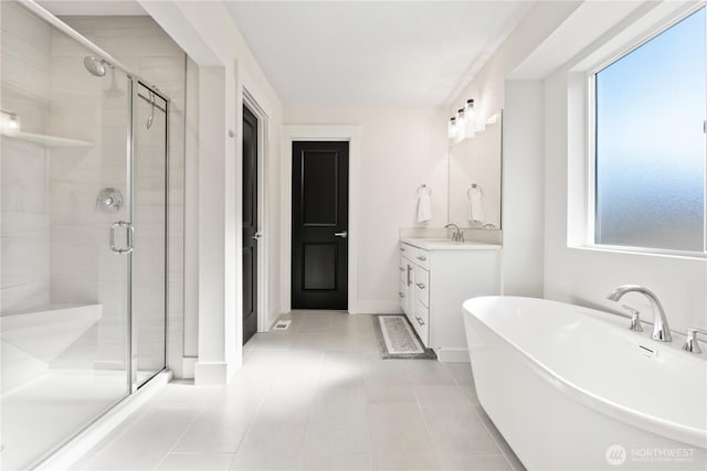 bathroom featuring vanity, separate shower and tub, a wealth of natural light, and tile patterned floors