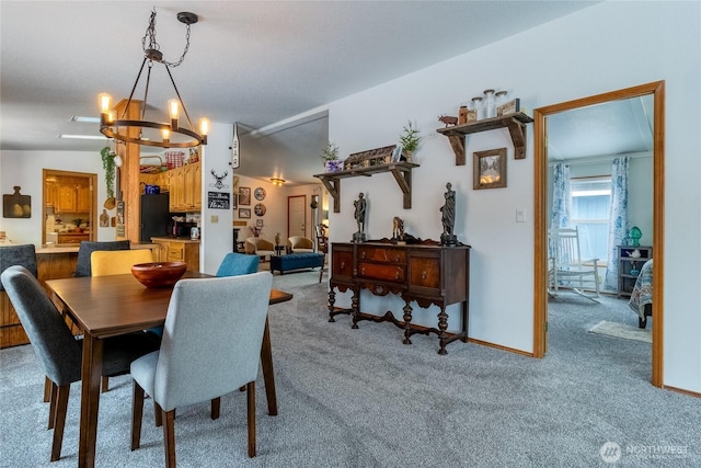 carpeted dining room featuring an inviting chandelier