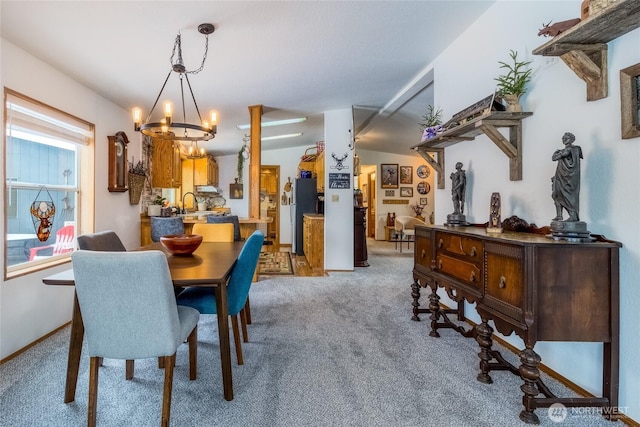 carpeted dining room featuring a notable chandelier and sink