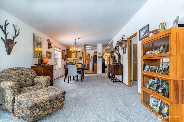 sitting room with carpet, a notable chandelier, and a textured ceiling