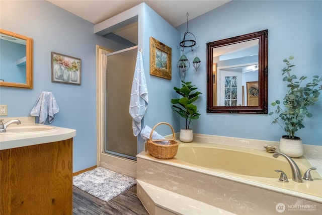 bathroom featuring wood-type flooring, separate shower and tub, and vanity