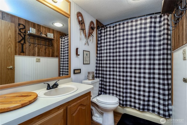 bathroom with vanity, toilet, and a textured ceiling