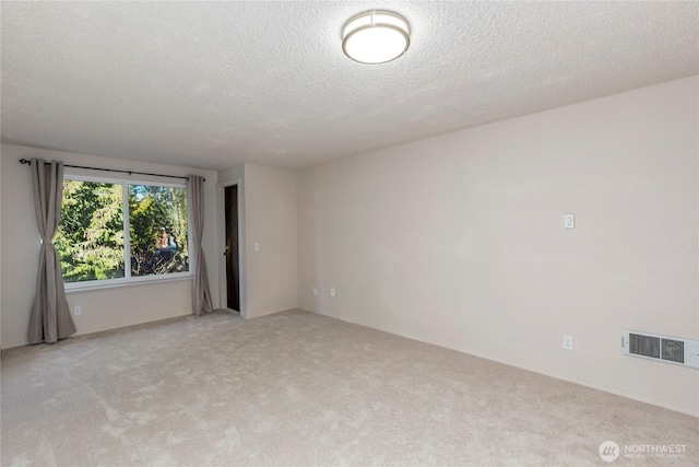 unfurnished room featuring light carpet and a textured ceiling