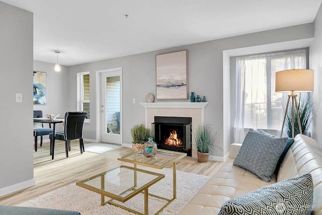 living room with light hardwood / wood-style floors and a tile fireplace