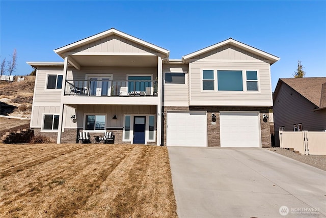 view of front of house with an attached garage, board and batten siding, fence, a balcony, and driveway