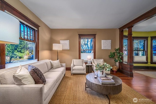 living room with hardwood / wood-style floors and ornate columns