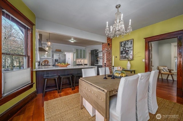 dining room featuring an inviting chandelier, dark hardwood / wood-style flooring, and sink