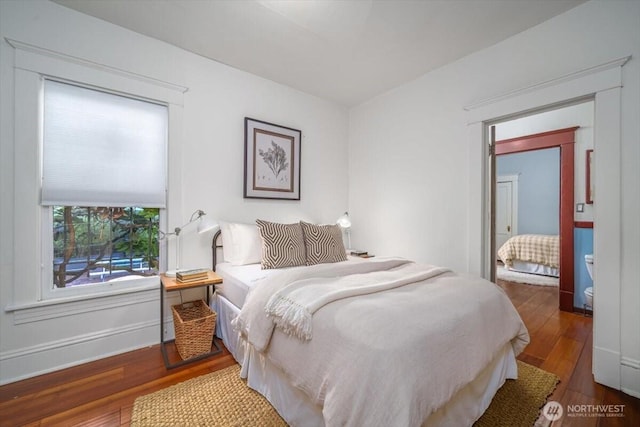 bedroom with dark hardwood / wood-style flooring