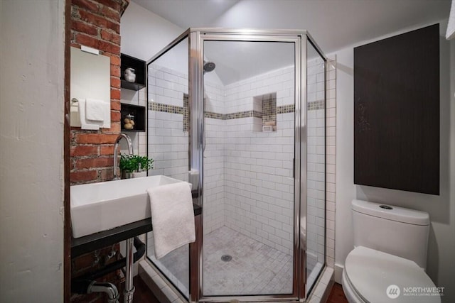 bathroom with an enclosed shower, sink, and toilet