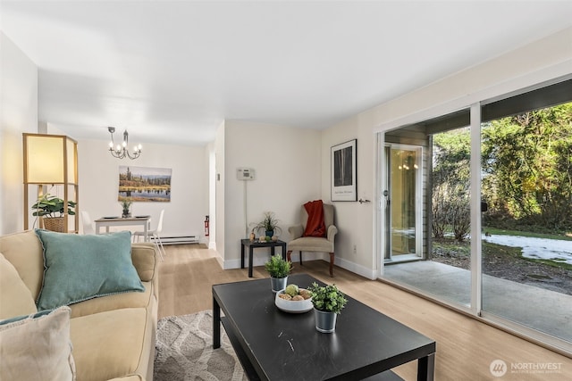 living room with an inviting chandelier, light wood-type flooring, and baseboard heating