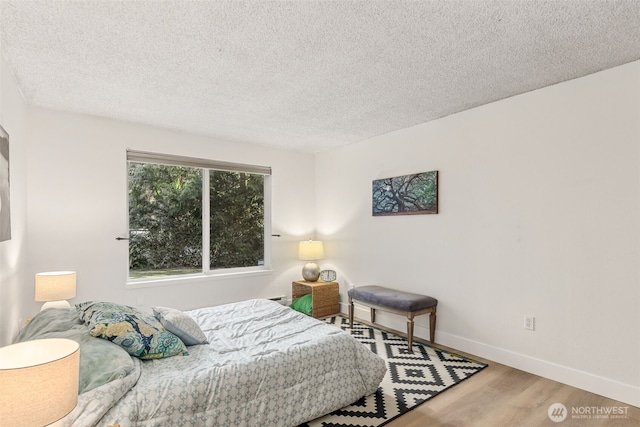 bedroom with hardwood / wood-style flooring and a textured ceiling