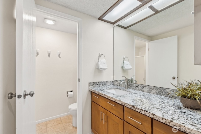 bathroom featuring vanity, tile patterned floors, a textured ceiling, and toilet