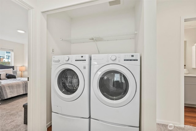 laundry area with washing machine and clothes dryer and carpet flooring