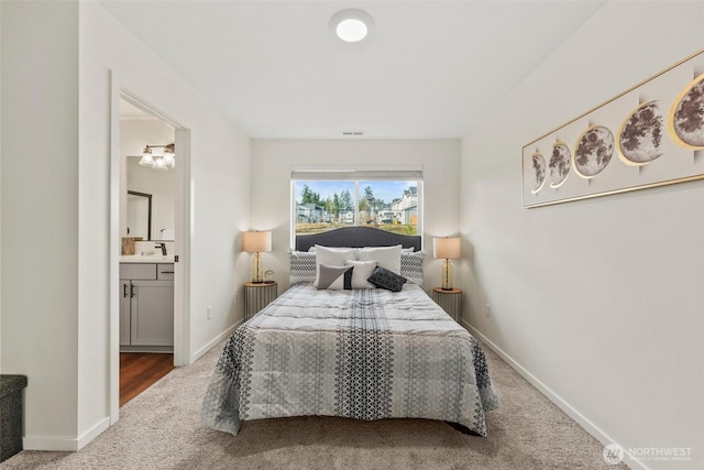 bedroom with sink, ensuite bath, and carpet